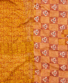kantha quilt throw with a tag featuring the hand-stitched signature of the maker