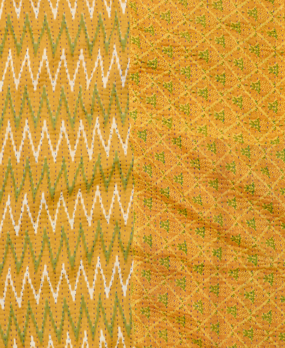 kantha quilt throw with a tag featuring the hand-stitched signature of the maker