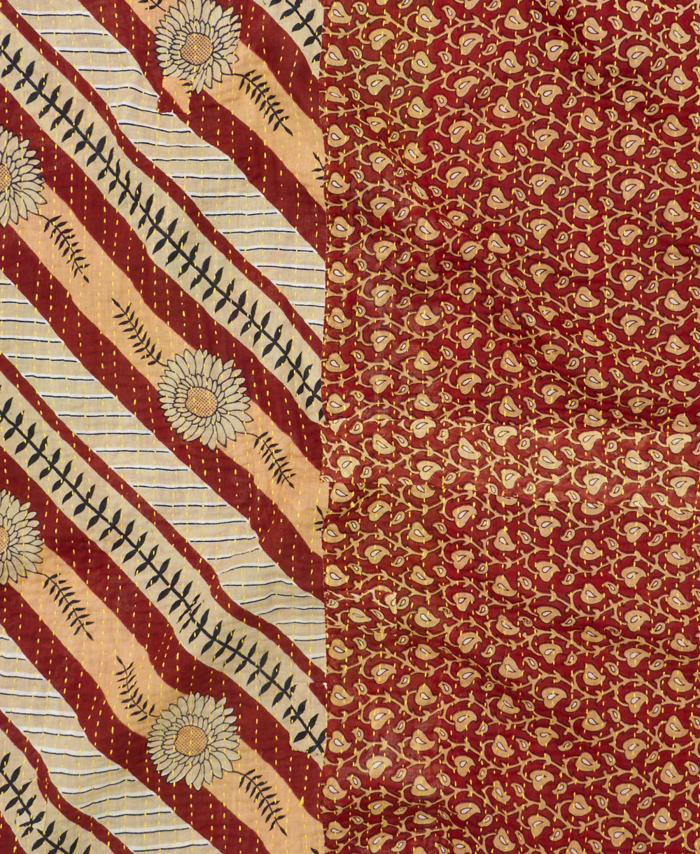 kantha quilt throw with a tag featuring the hand-stitched signature of the maker