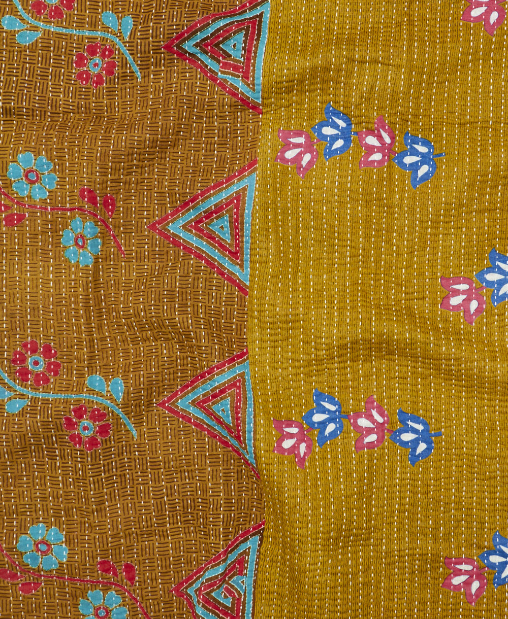 kantha quilt throw with a tag featuring the hand-stitched signature of the maker