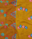 kantha quilt throw with a tag featuring the hand-stitched signature of the maker