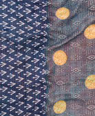 kantha quilt throw with a tag featuring the hand-stitched signature of the maker