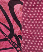 kantha quilt throw with a tag featuring the hand-stitched signature of the maker