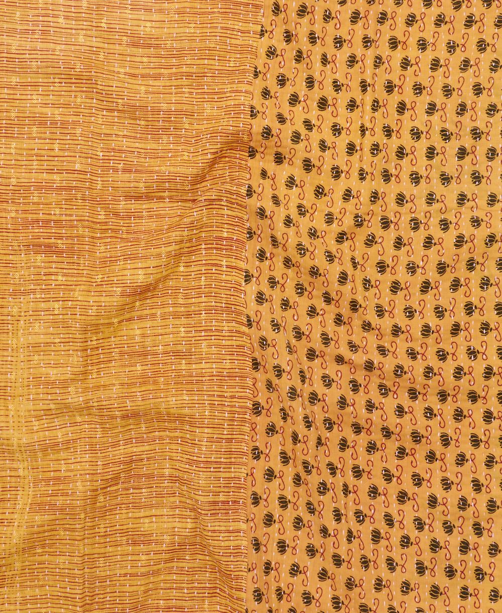 kantha quilt throw with a tag featuring the hand-stitched signature of the maker