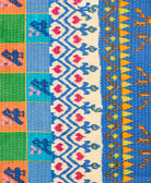 kantha quilt throw with a tag featuring the hand-stitched signature of the maker