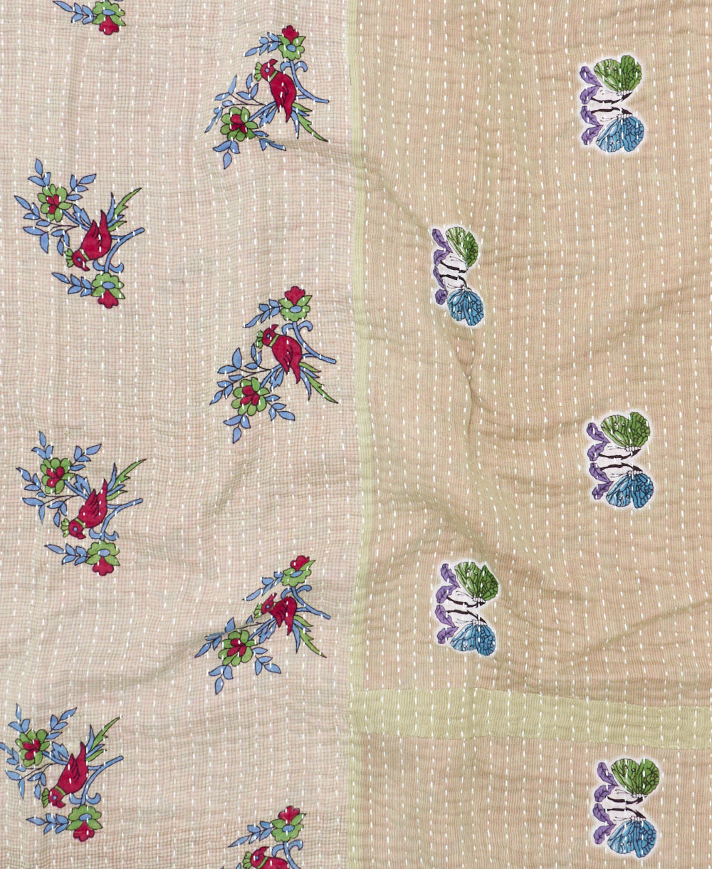 kantha quilt throw with a tag featuring the hand-stitched signature of the maker