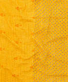 kantha quilt throw with a tag featuring the hand-stitched signature of the maker