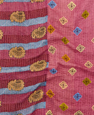 kantha quilt throw with a tag featuring the hand-stitched signature of the maker