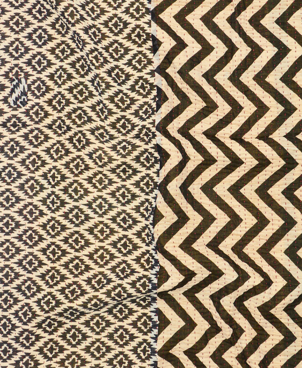 kantha quilt throw with a tag featuring the hand-stitched signature of the maker