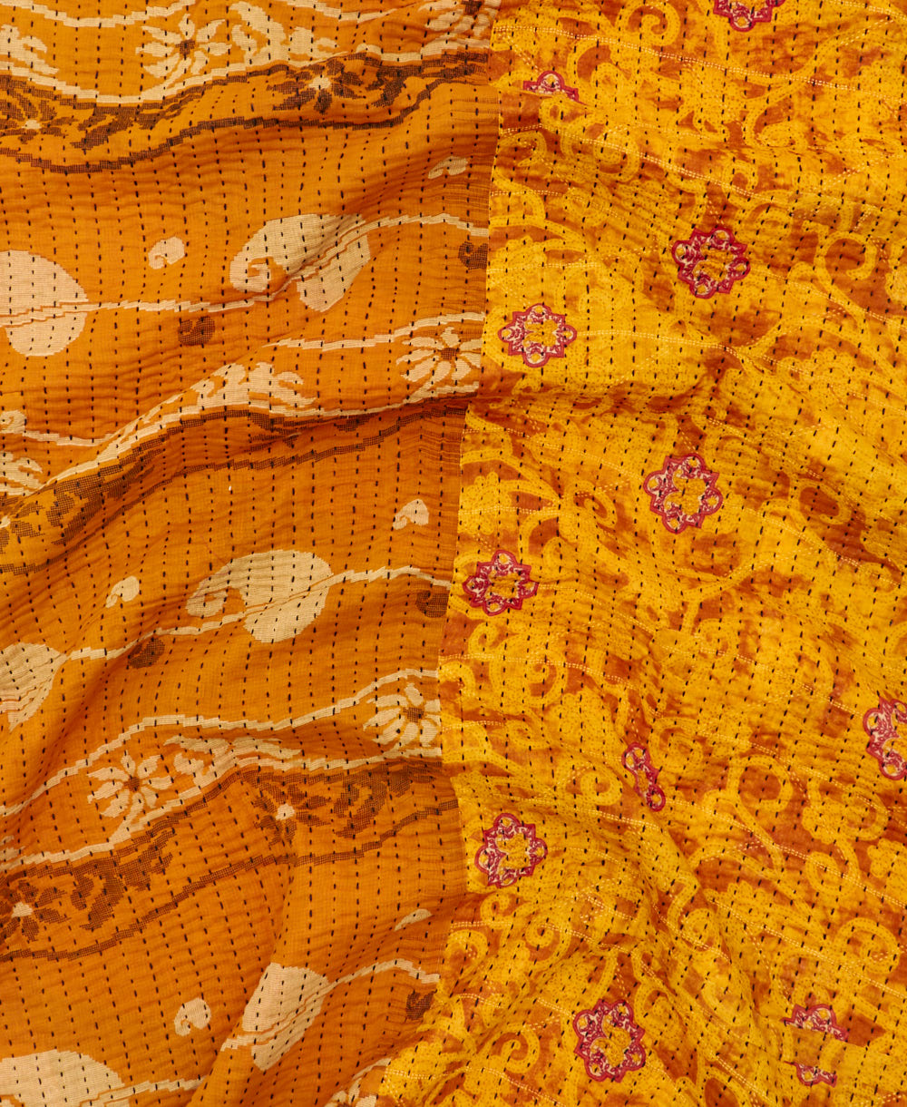 kantha quilt throw with a tag featuring the hand-stitched signature of the maker