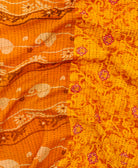 kantha quilt throw with a tag featuring the hand-stitched signature of the maker