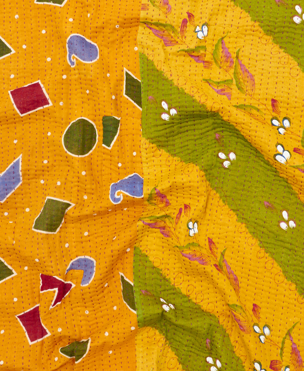 kantha quilt throw with a tag featuring the hand-stitched signature of the maker