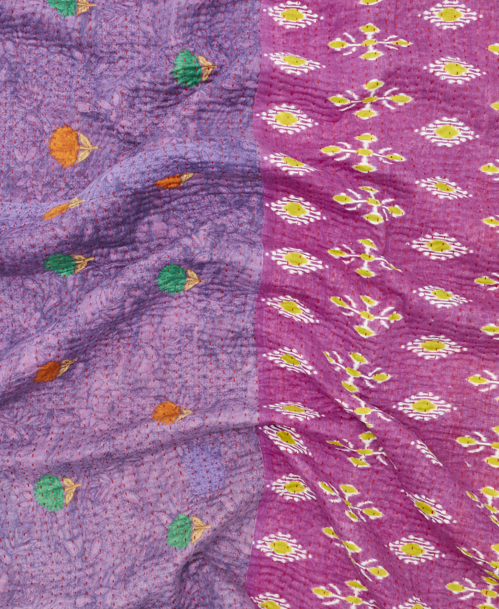 kantha quilt throw with a tag featuring the hand-stitched signature of the maker