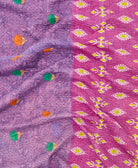 kantha quilt throw with a tag featuring the hand-stitched signature of the maker