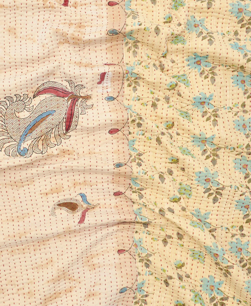 kantha quilt throw with a tag featuring the hand-stitched signature of the maker