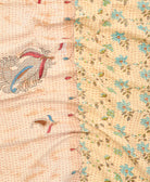 kantha quilt throw with a tag featuring the hand-stitched signature of the maker