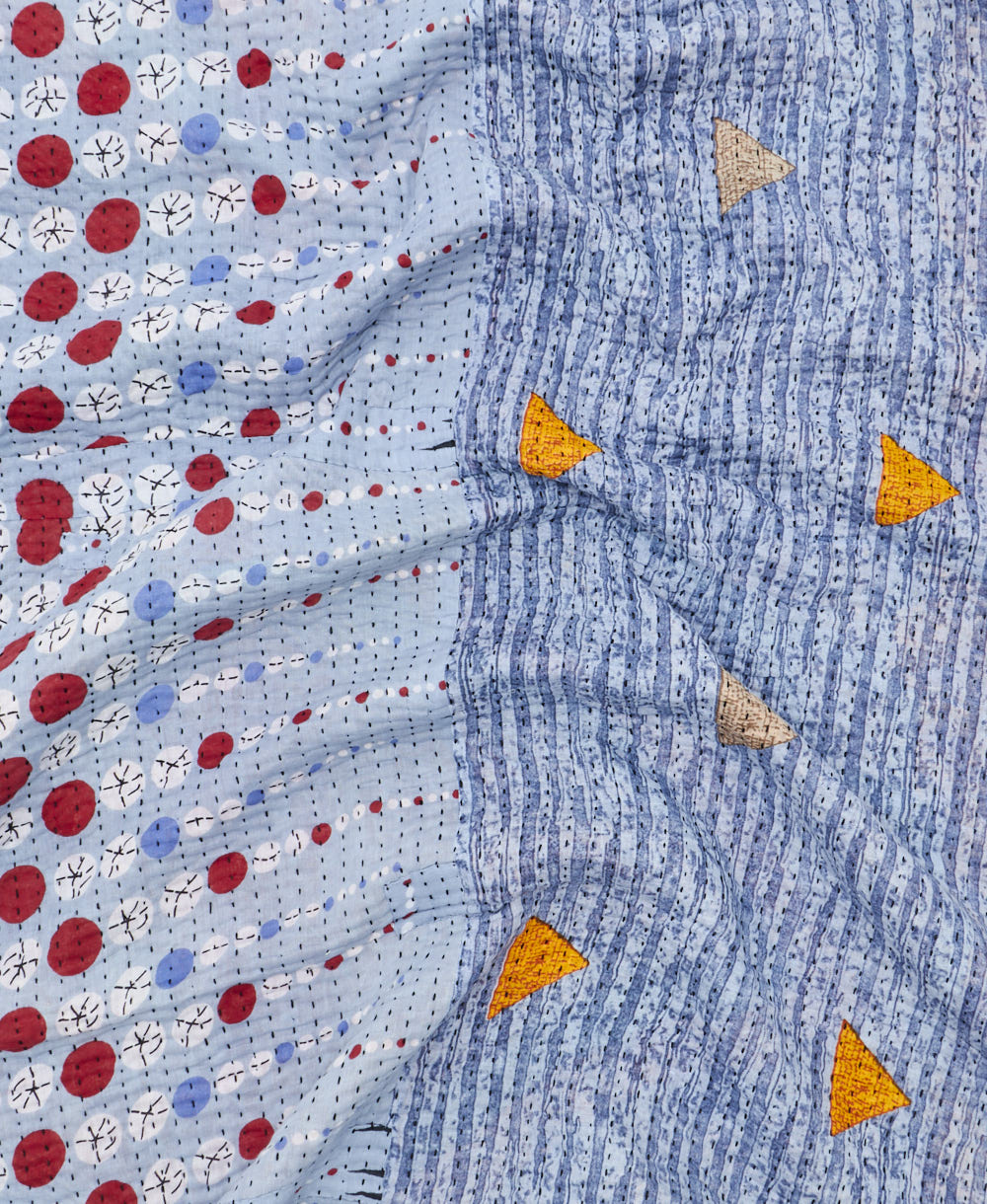 kantha quilt throw with a tag featuring the hand-stitched signature of the maker