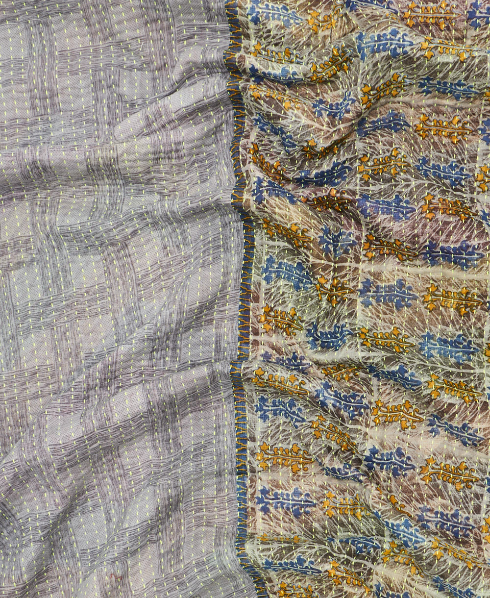 kantha quilt throw with a tag featuring the hand-stitched signature of the maker