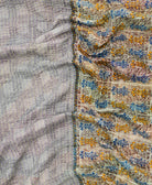 kantha quilt throw with a tag featuring the hand-stitched signature of the maker
