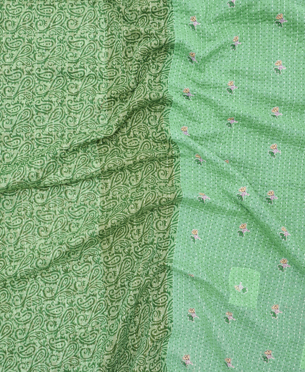 kantha quilt throw with a tag featuring the hand-stitched signature of the maker