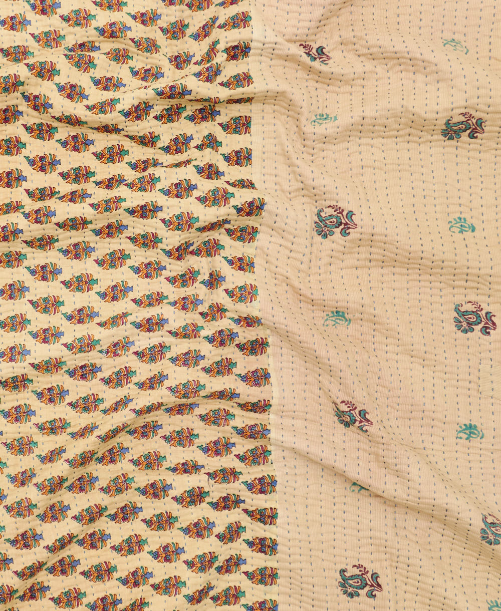 kantha quilt throw with a tag featuring the hand-stitched signature of the maker
