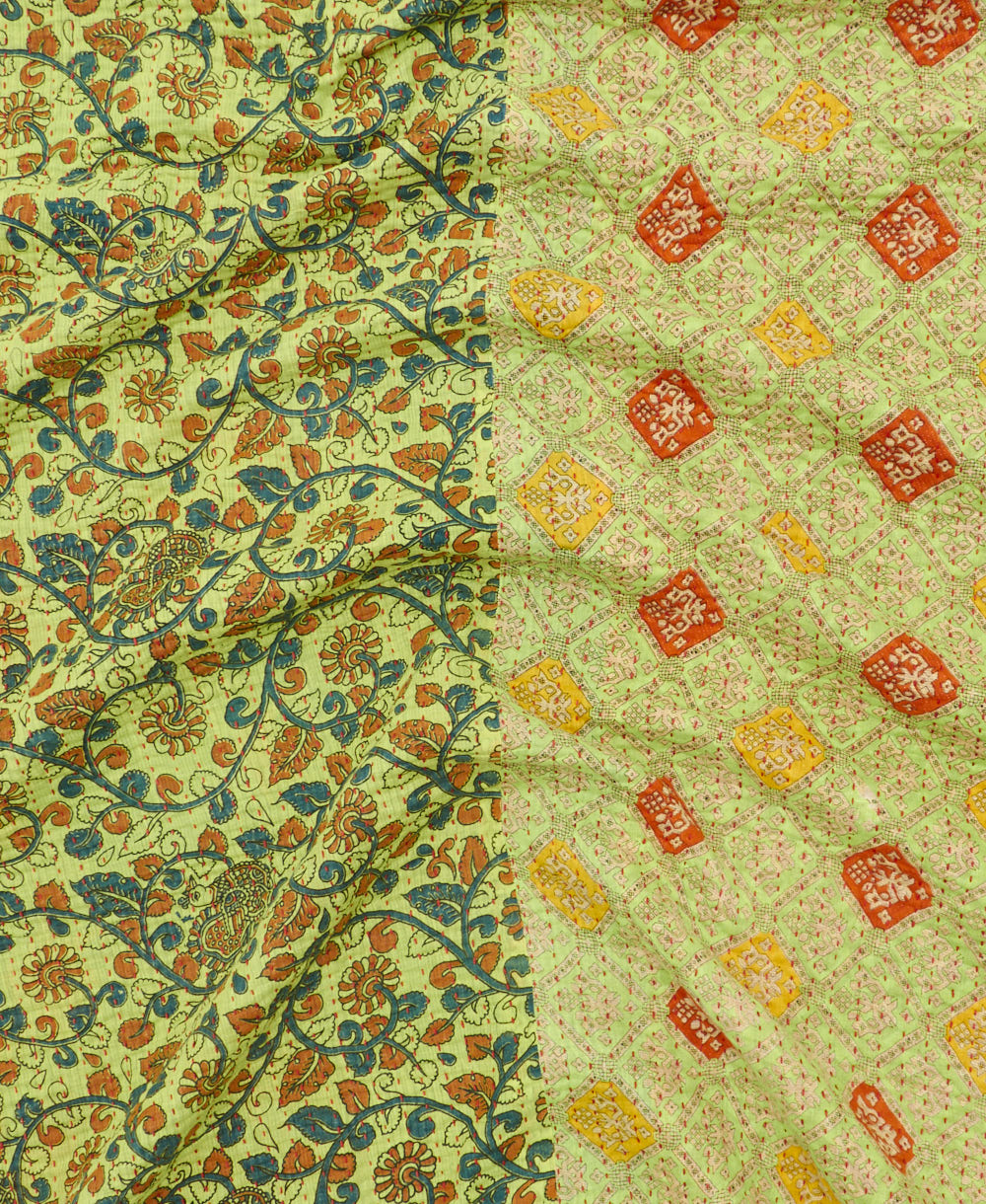 kantha quilt throw with a tag featuring the hand-stitched signature of the maker