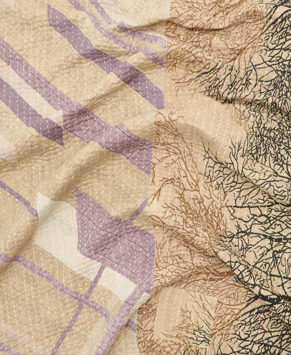kantha quilt throw with a tag featuring the hand-stitched signature of the maker