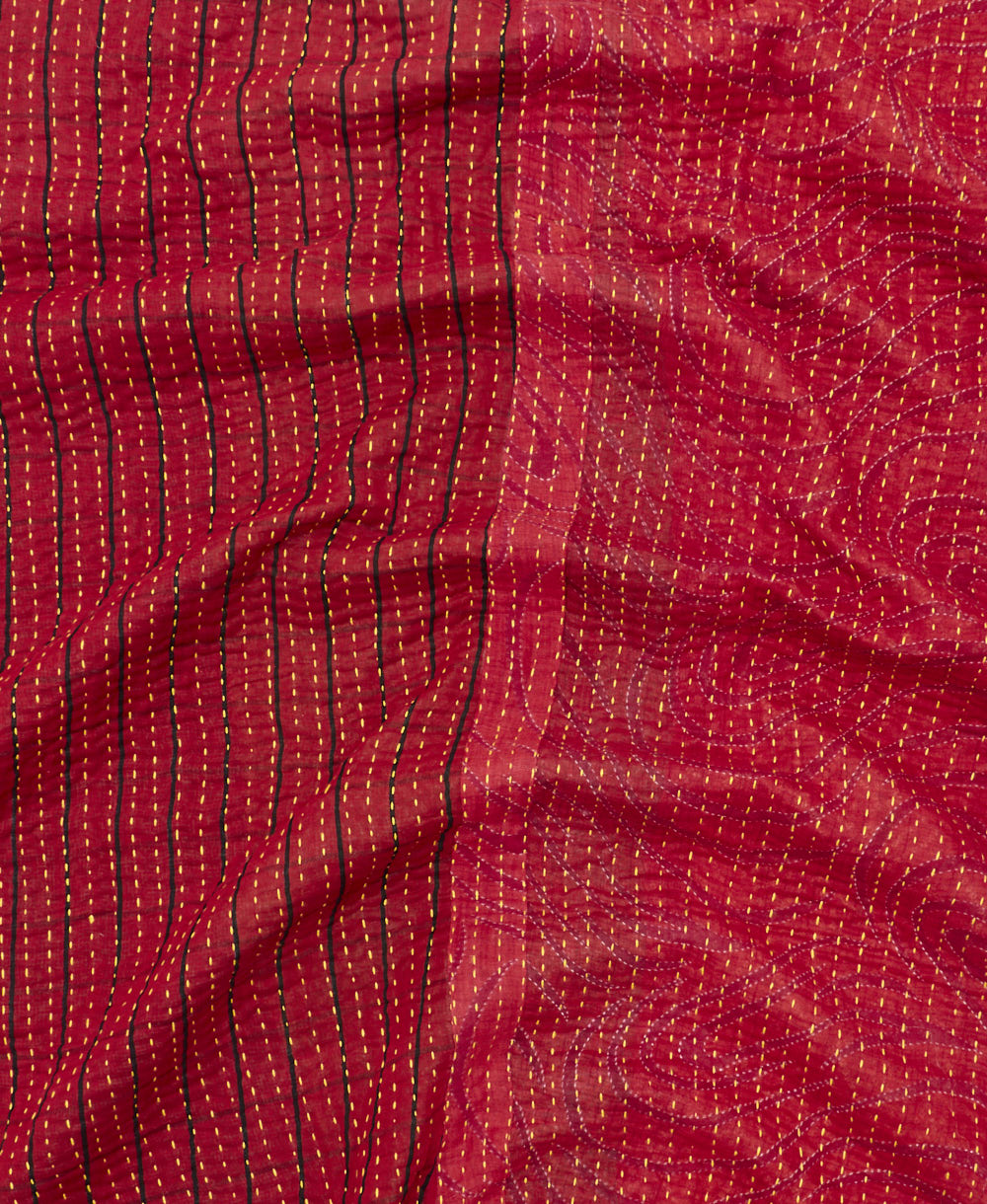 kantha quilt throw with a tag featuring the hand-stitched signature of the maker