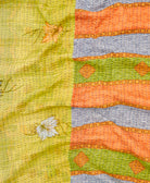 kantha quilt throw with a tag featuring the hand-stitched signature of the maker
