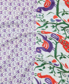 kantha quilt throw with a tag featuring the hand-stitched signature of the maker