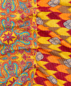 kantha quilt throw with a tag featuring the hand-stitched signature of the maker