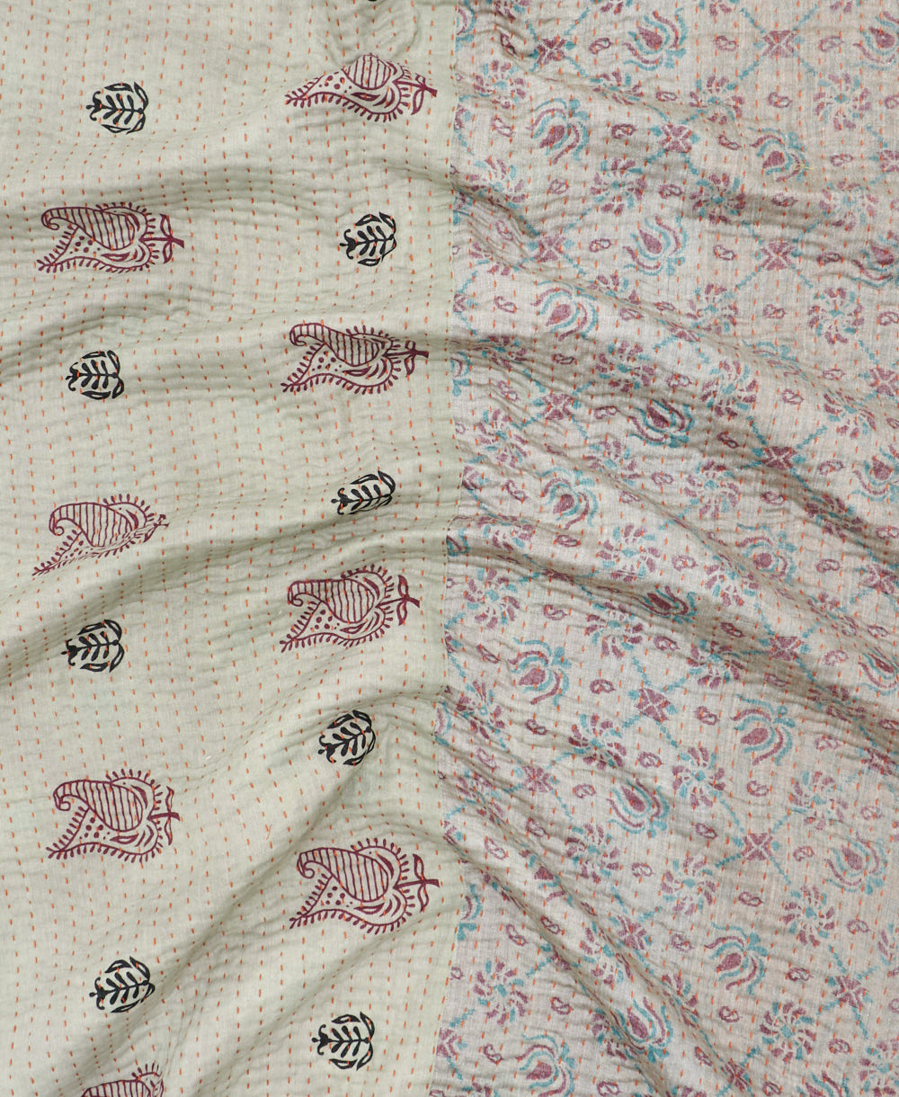 kantha quilt throw with a tag featuring the hand-stitched signature of the maker