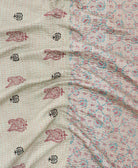 kantha quilt throw with a tag featuring the hand-stitched signature of the maker
