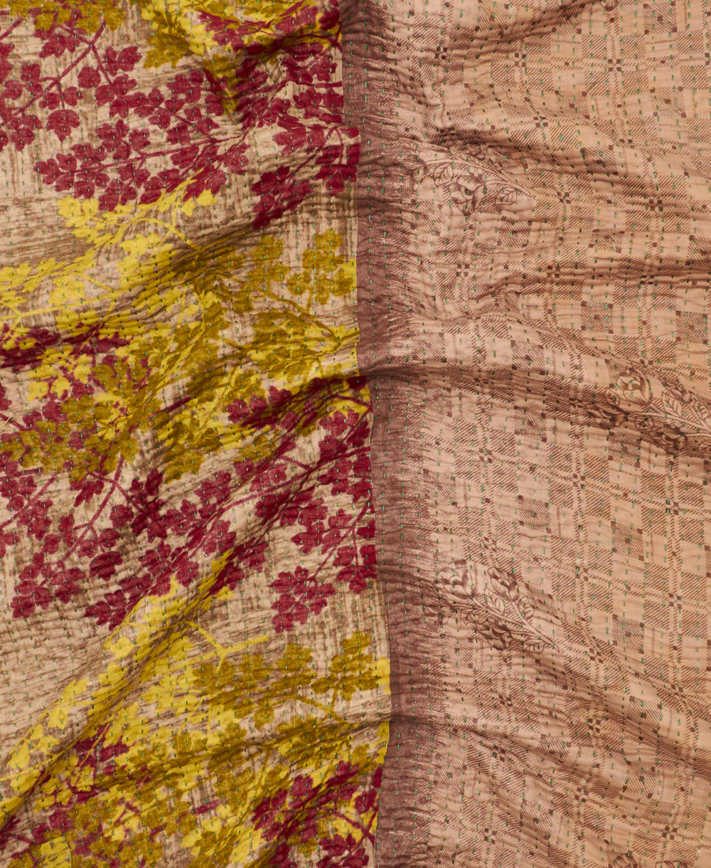 kantha quilt throw with a tag featuring the hand-stitched signature of the maker