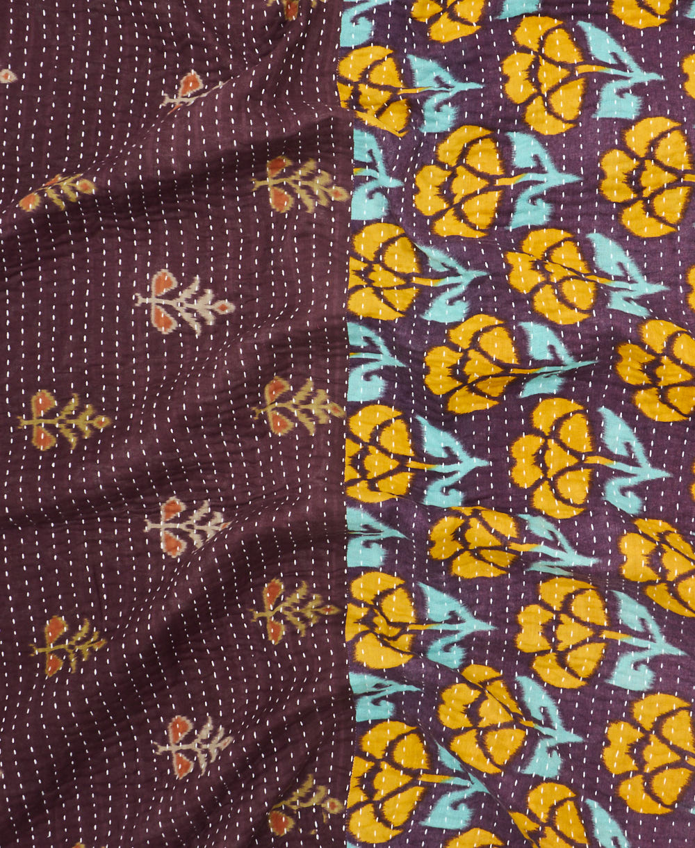 kantha quilt throw with a tag featuring the hand-stitched signature of the maker