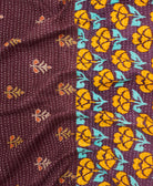 kantha quilt throw with a tag featuring the hand-stitched signature of the maker