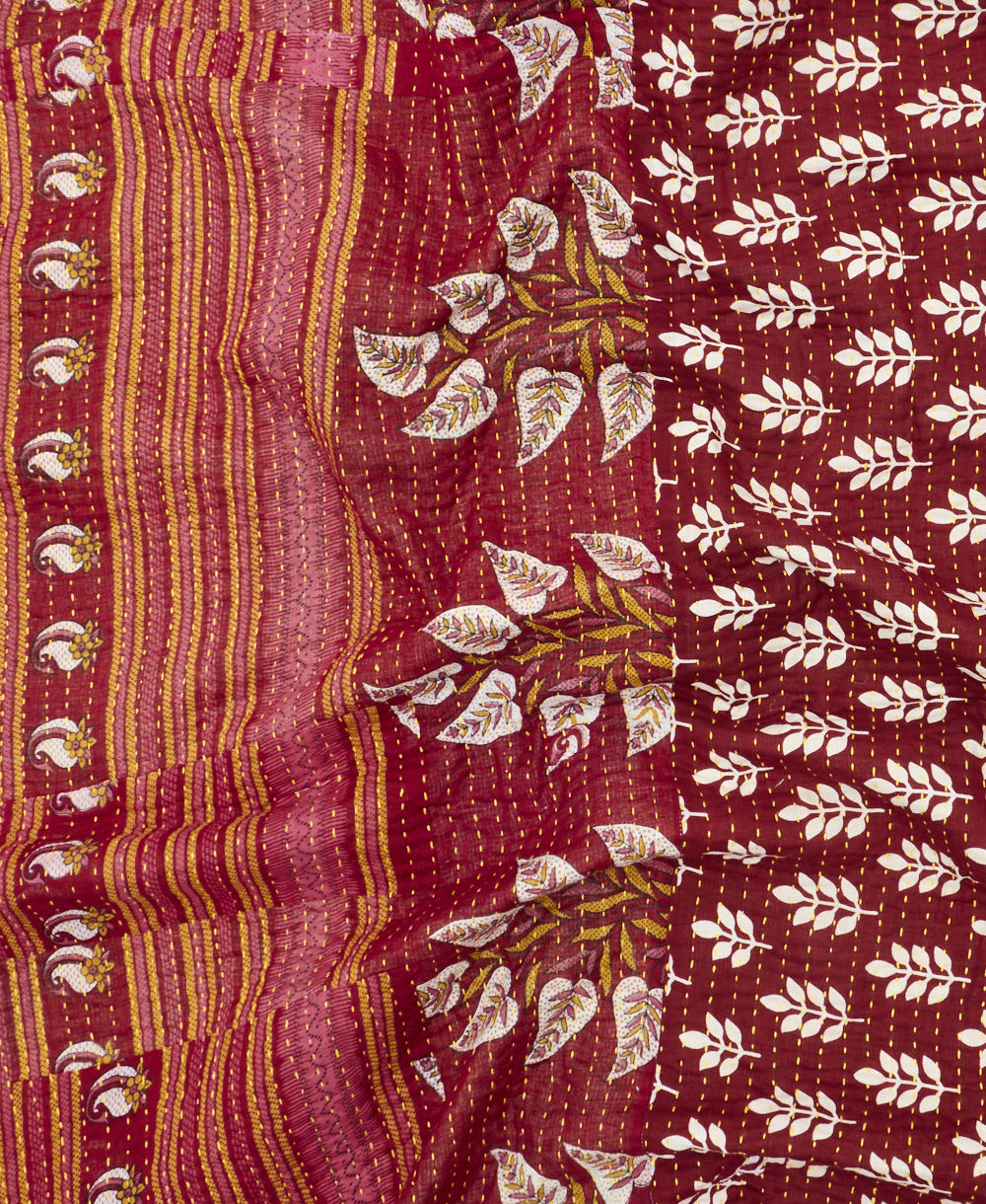 kantha quilt throw with a tag featuring the hand-stitched signature of the maker
