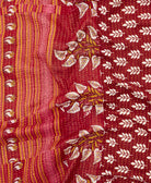 kantha quilt throw with a tag featuring the hand-stitched signature of the maker