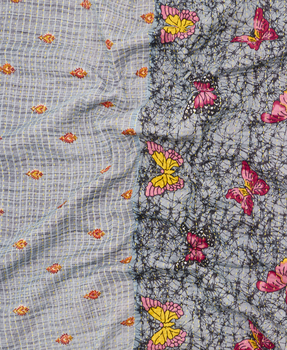 kantha quilt throw with a tag featuring the hand-stitched signature of the maker