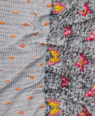 kantha quilt throw with a tag featuring the hand-stitched signature of the maker