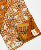 kantha quilt throw with a tag featuring the hand-stitched signature of the maker