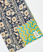 kantha quilt throw with a tag featuring the hand-stitched signature of the maker