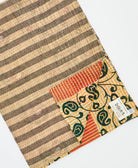 kantha quilt throw with a tag featuring the hand-stitched signature of the maker