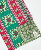 kantha quilt throw with a tag featuring the hand-stitched signature of the maker