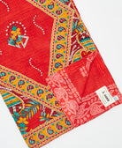kantha quilt throw with a tag featuring the hand-stitched signature of the maker