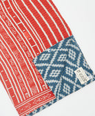 kantha quilt throw with a tag featuring the hand-stitched signature of the maker