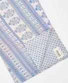 kantha quilt throw with a tag featuring the hand-stitched signature of the maker