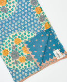 kantha quilt throw with a tag featuring the hand-stitched signature of the maker
