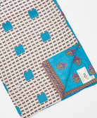 kantha quilt throw with a tag featuring the hand-stitched signature of the maker
