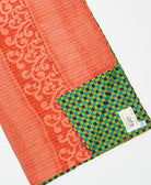 kantha quilt throw with a tag featuring the hand-stitched signature of the maker